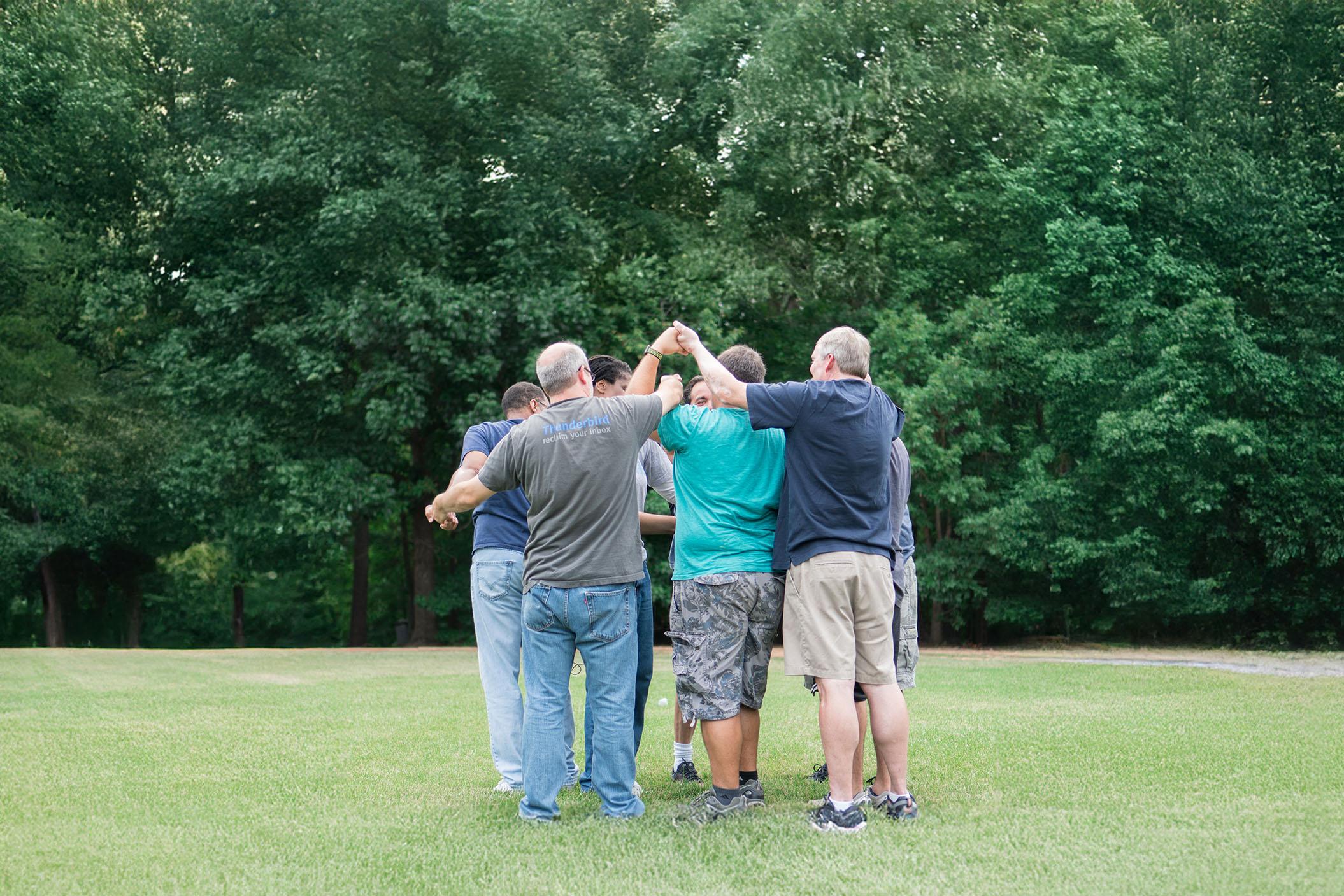 Group of adults huddling up as a team
