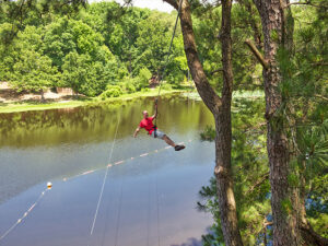 A man flying down a zipline across a lake in Memphis, Tennessee