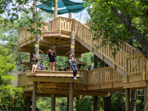 Two girls racing down dueling ziplines in Arlington, Texas