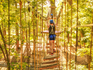 A young person on an epic treetop obstacle in Ocean City, Maryland