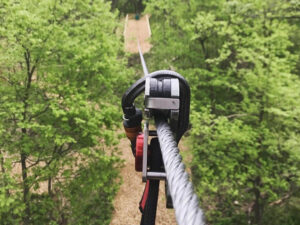 A view looking down a zipline through a beautiful forest canopy in Omaha-Lincoln, Nebraska