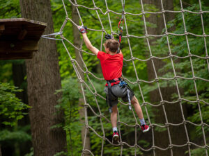 A young boy conquering the epic Tarzan swing in the trees in Cleveland, Ohio