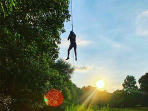 A person flying down a zipline in the forest in Raleigh-Durham, North Carolina