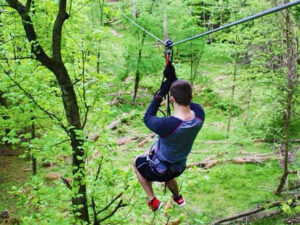 A man flying down a forest zipline in Cleveland, Ohio